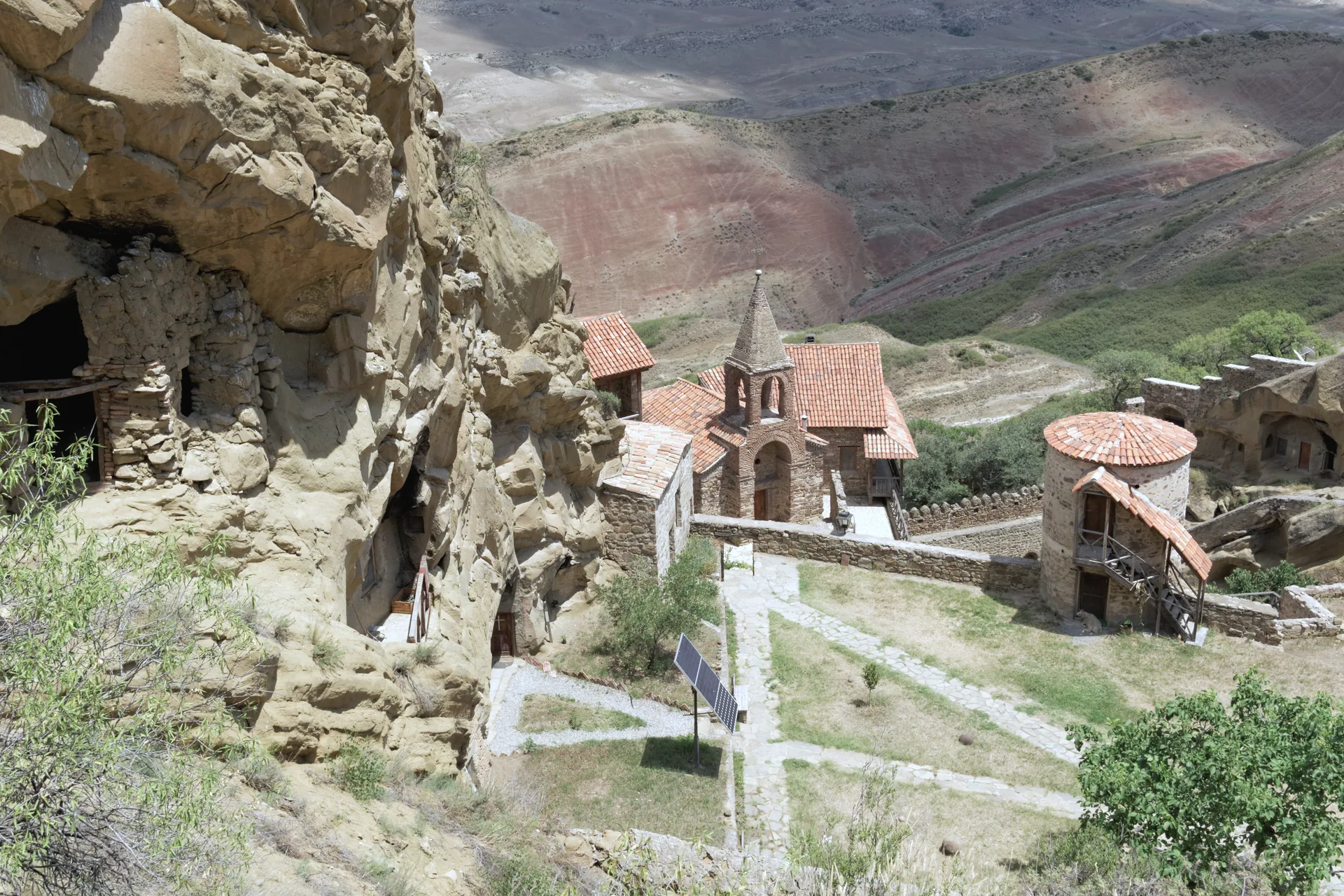 The Lavra of David Gareja below its cliff cells, the striped red and green hills behind