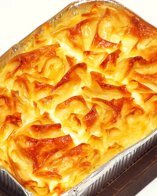The golden layered top of an achma cheese pie