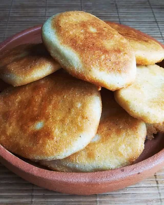 Golden mchadi cornbread cakes piled in a clay bowl
