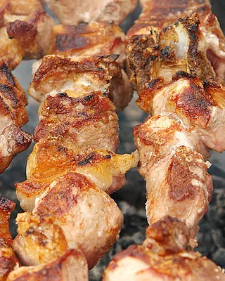 Mtsvadi, pork skewers browning over the coals