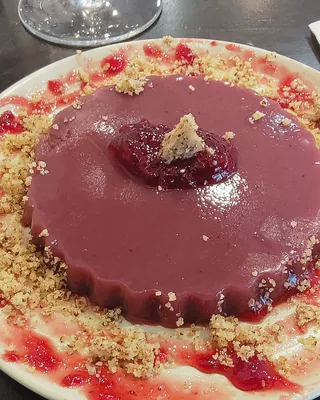 A round of deep red pelamushi pudding ringed with crushed walnuts