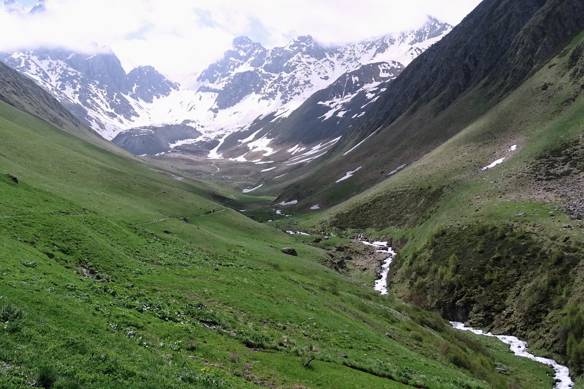 The road valley from Juta toward the Chaukhi massif, snow still on the peaks in June