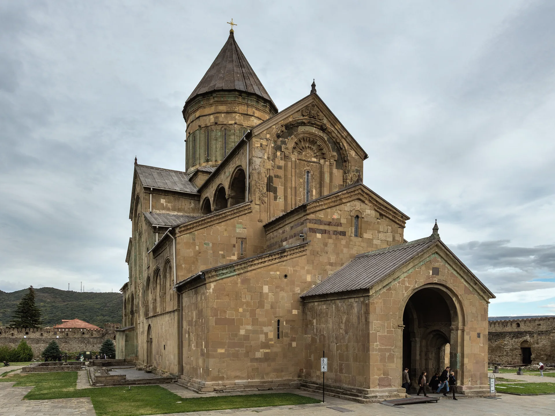 The stone cathedral of Svetitskhoveli with its tall conical dome under a grey autumn sky
