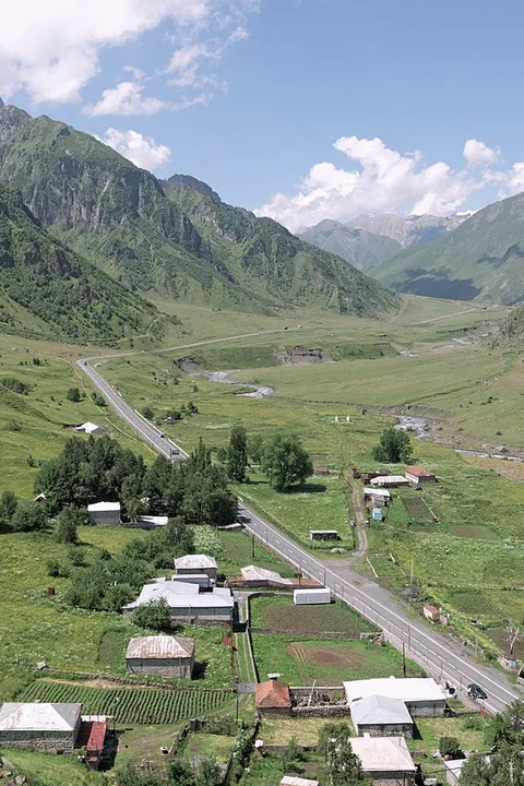 The Georgian Military Road running through a green valley at Sioni
