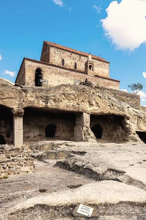 The rock-hewn halls of Uplistsikhe under a stone basilica