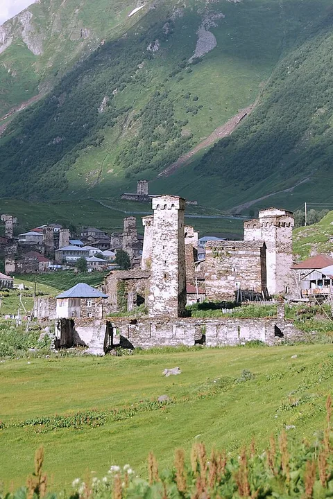 The towers of Ushguli in a bright green summer valley